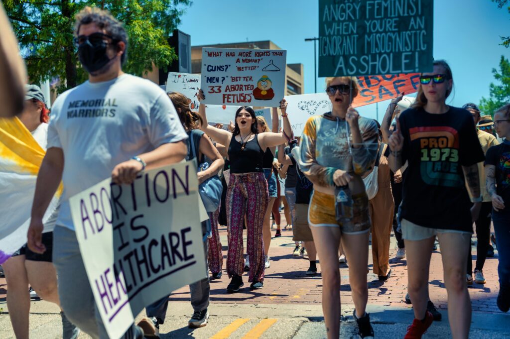 WHISPERS OF AUTONOMY: DELVING INTO ABORTION RIGHTS FOR UNMARRIED WOMEN IN INDIA A diverse crowd protesting for women's rights and healthcare access in a peaceful demonstration.