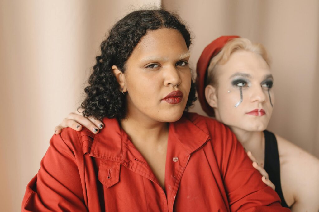 ANALYSIS OF TRANSGENDER RIGHTS IN INDIA Close-up of two diverse friends with makeup and unique style embracing indoors.