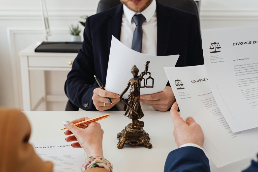 A-COMPREHENSIVE-ANALYSIS-OF-PRISONERS-RIGHTS-FROM-PUNISHMENT-TO-REFORM Legal professionals reviewing divorce documents in a law office with a Lady Justice statue.