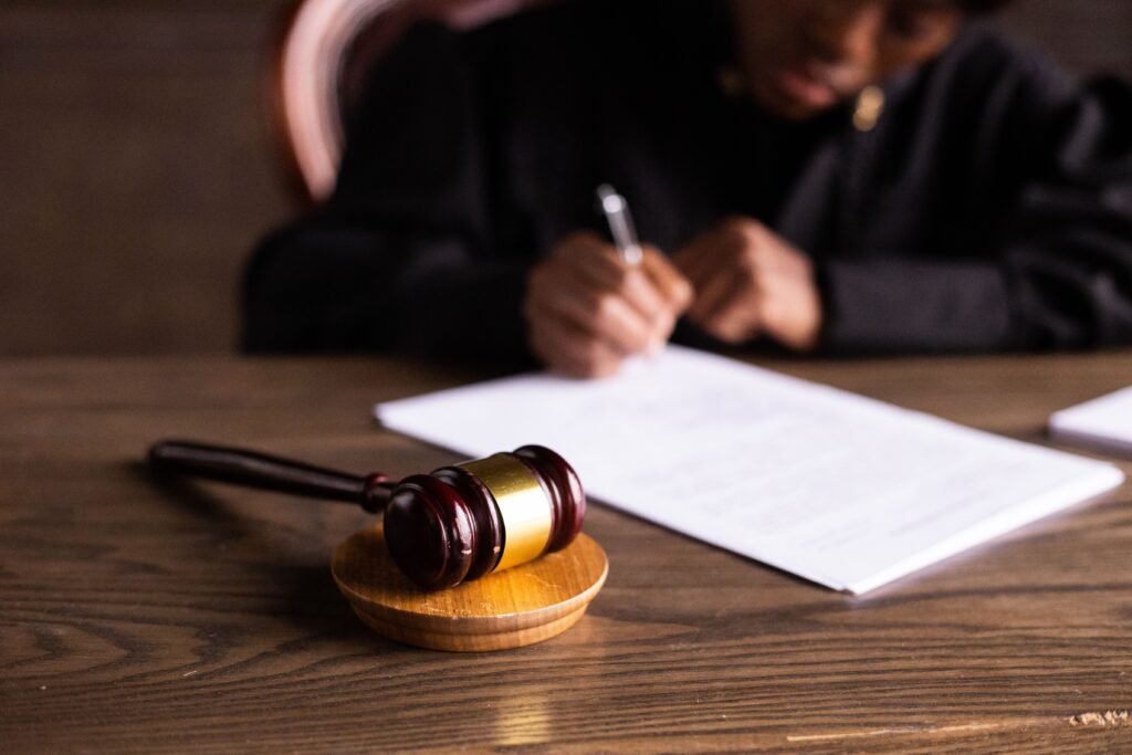 MATERNITY LEAVE AS A CONSTITUTIONAL RIGHT IN INDIA: A NEW CHAPTER IN GENDER JUSTICE Judge signing documents at desk with focus on gavel, representing law and justice.